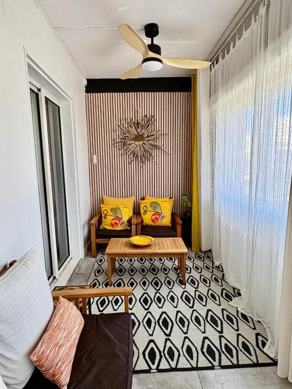 Petit salon avec fauteuils et coussins jaunes · © Lelaleu