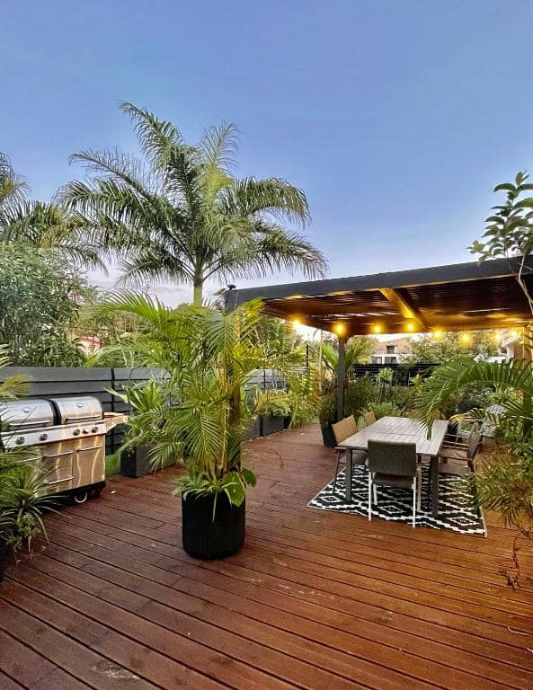Terrasse en teck avec barbecue et pergola éclairée · © Lelaleu