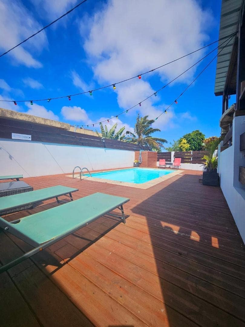 Piscine, deck en bois et guirlande d'ampoules · © Les bungalows du château d'Ô