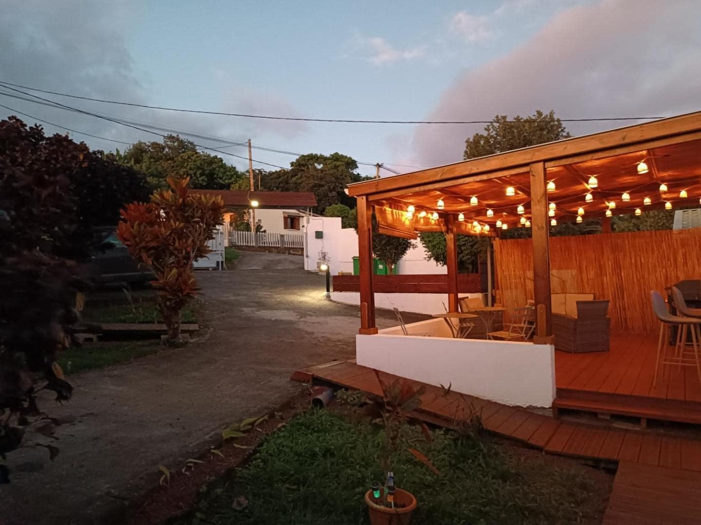 Pergola éclairée à la tombée du soir · © Les bungalows du château d'Ô