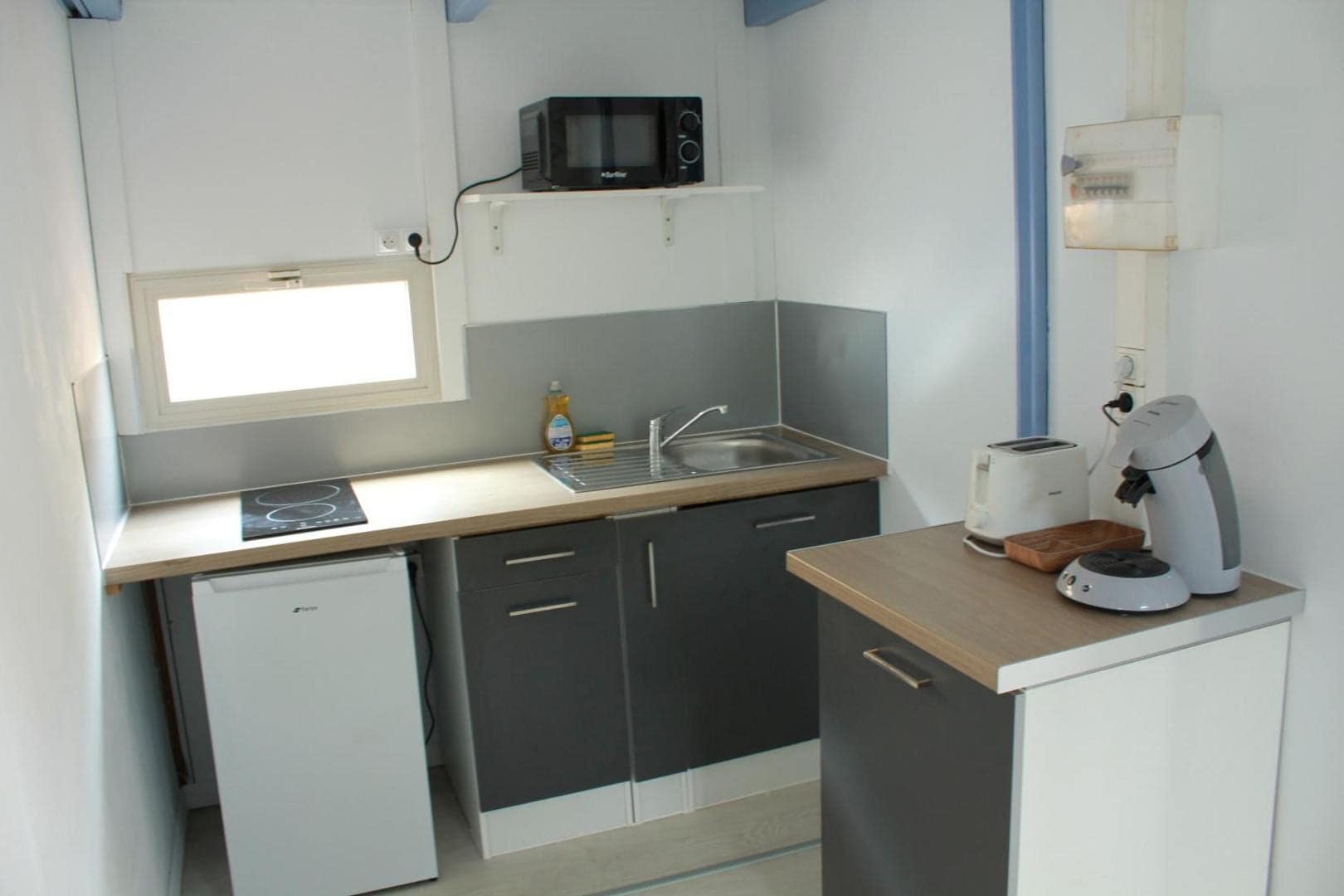 Kitchenette compacte du bungalow · © Les bungalows du château d'Ô