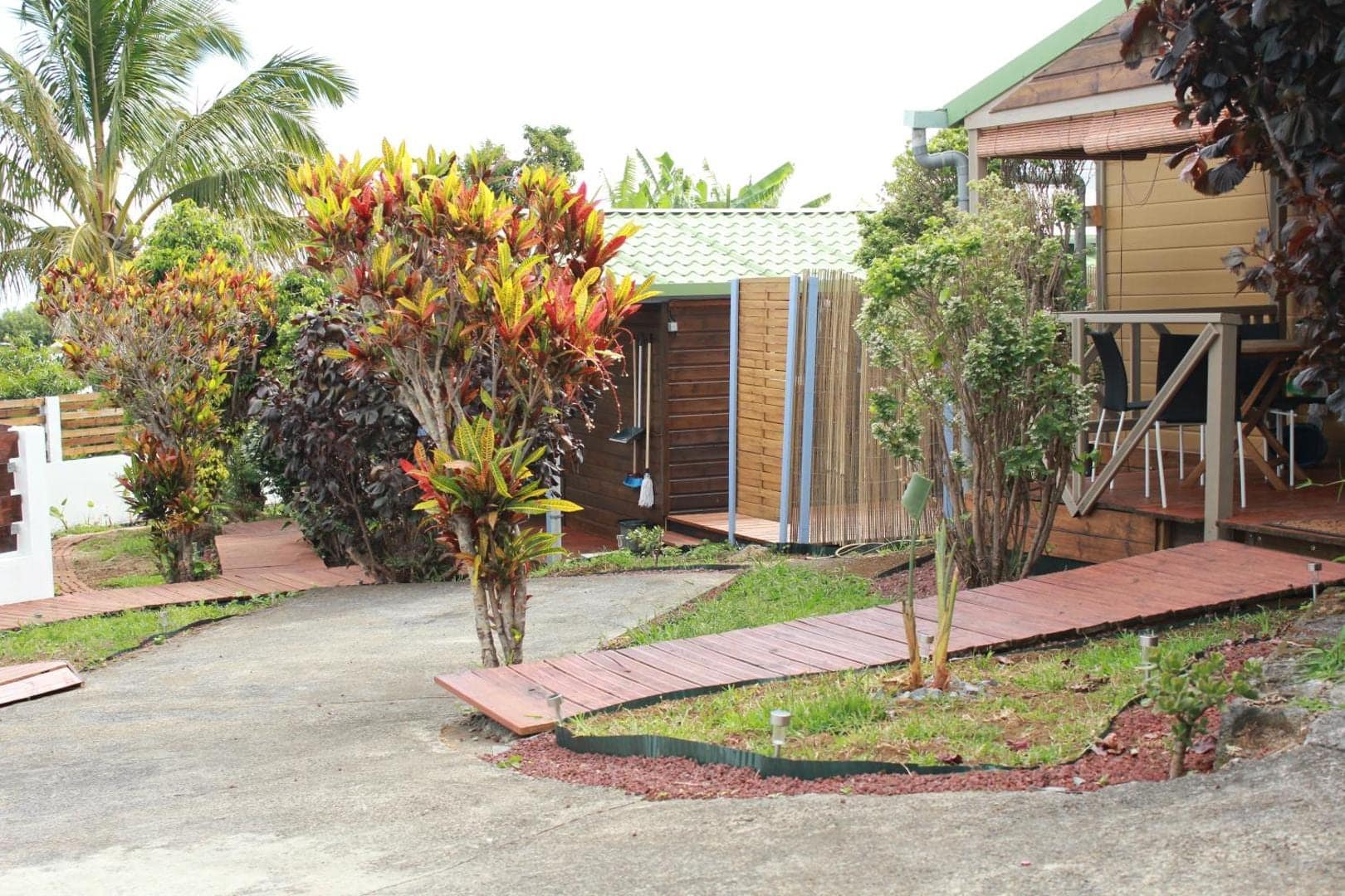 Allée du jardin et bungalows sous les crotons · © Les bungalows du château d'Ô