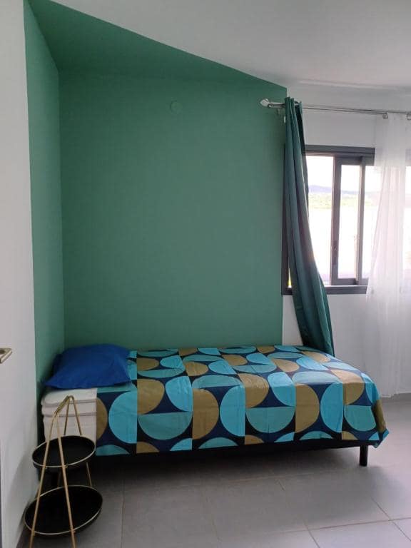 Chambre alcôve vert émeraude, banquette avec parure géométrique · © Les jumelles