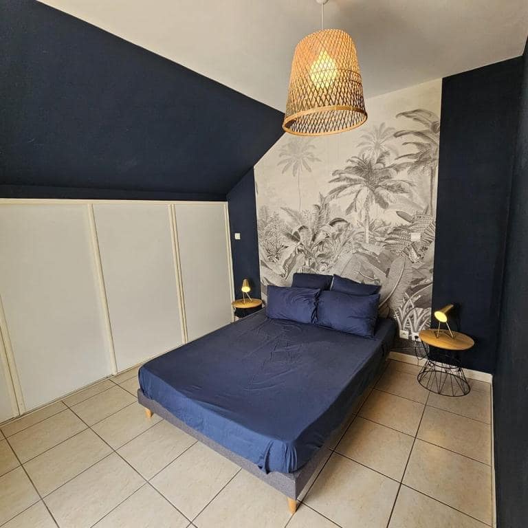 Autre chambre au papier peint jungle et suspension rotin · © Pieds dans l'eau