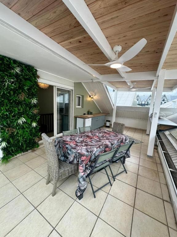 Terrasse couverte avec plafond bois, table et ventilateur · © Pieds dans l'eau