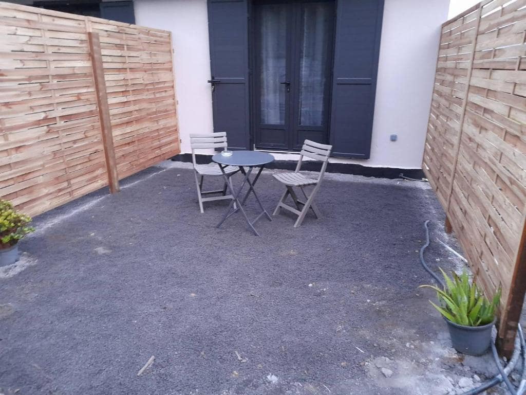 Petite terrasse close par palissade bois, table bistro et deux chaises · © Les Sommets de Salazie