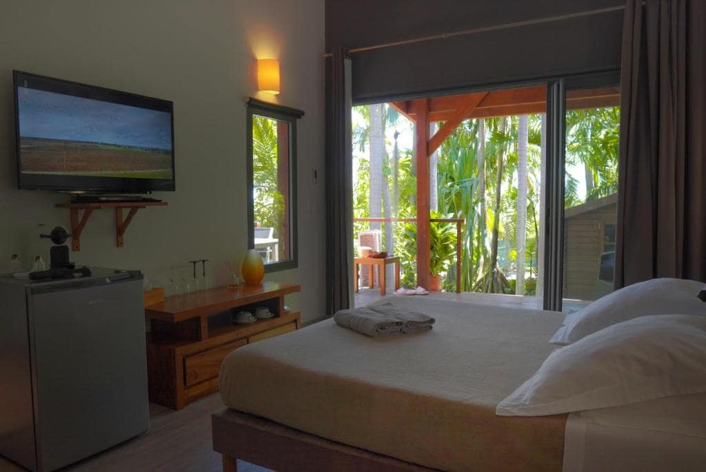 Chambre lit double ouverte sur la terrasse et le jardin · © Lodge Palmae