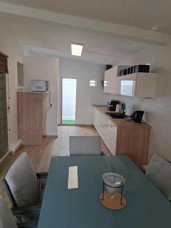 Cuisine galley avec plan bois et micro-ondes · © Sakina City
