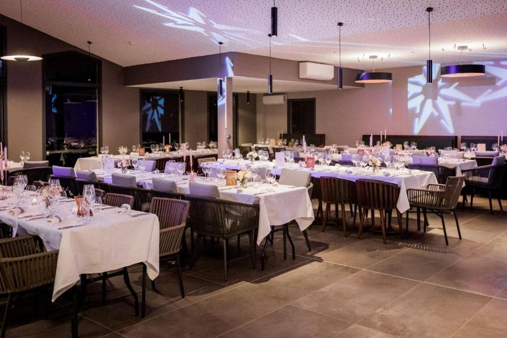 Autre salle, tablée dressée sous éclairage tamisé violet · © Sarana Hôtel & Spa