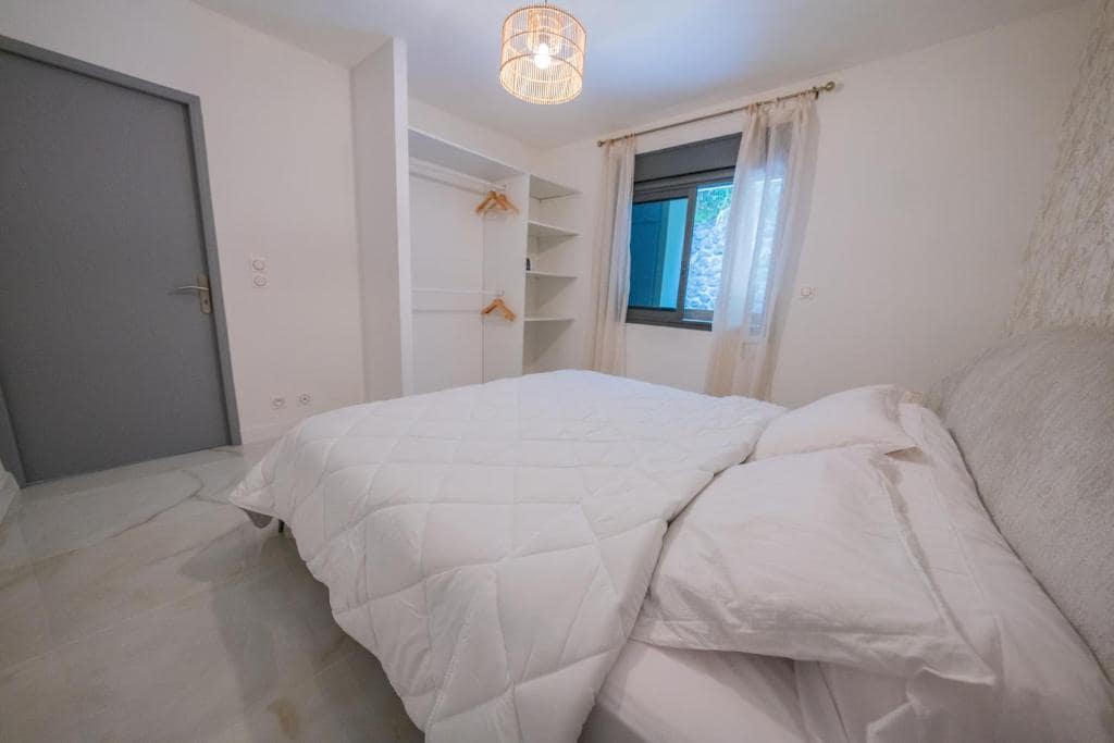 Chambre principale, lit double blanc et dressing ouvert · © Sea View & Spa