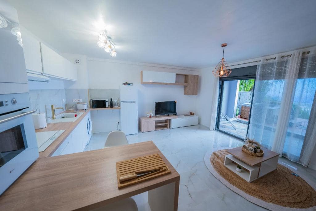 Séjour ouvert sur cuisine et baie vitrée côté terrasse · © Sea View & Spa