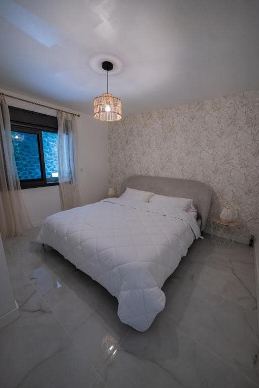 Autre chambre, tapisserie végétale et sol marbré · © Sea View & Spa
