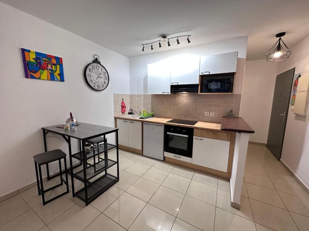 Kitchenette avec horloge murale grand format · © Studio Bellepierre vue mer