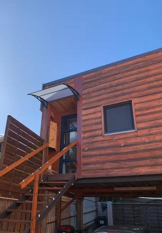 Chalet bois sur pilotis, escalier d'accès et carport · © Studio P ti koin trankil
