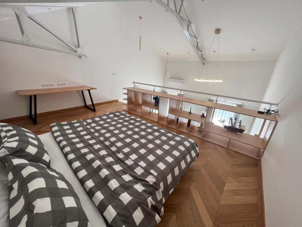 Mezzanine chambre, literie à carreaux gris-blanc · © Suite Deluxe Carré Cathédrale