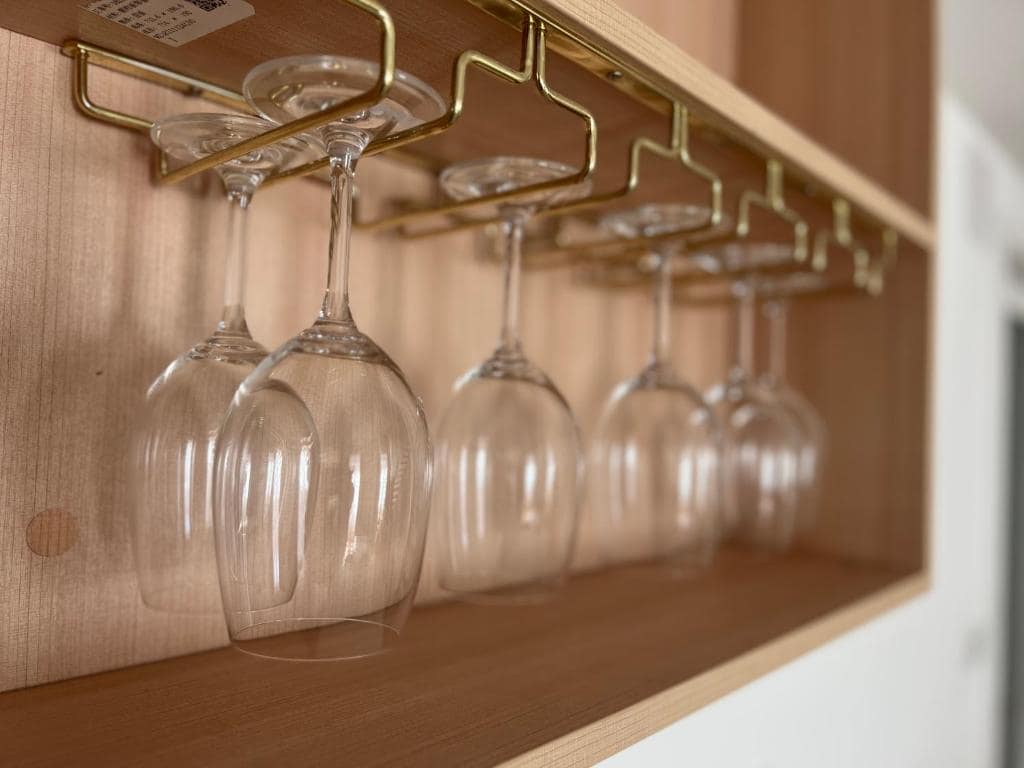 Verres à vin suspendus sous étagère de cuisine · © Suite Deluxe Carré Cathédrale