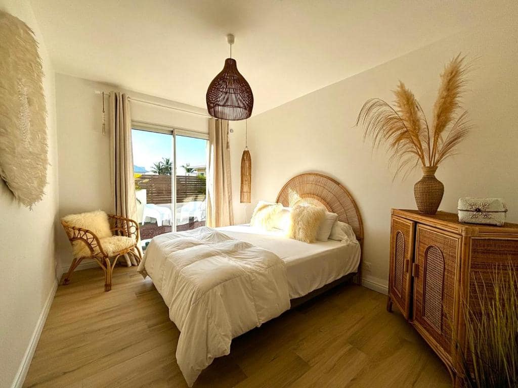 Chambre principale, tête de lit en rotin, pampas séchées · © Ti Cocoon