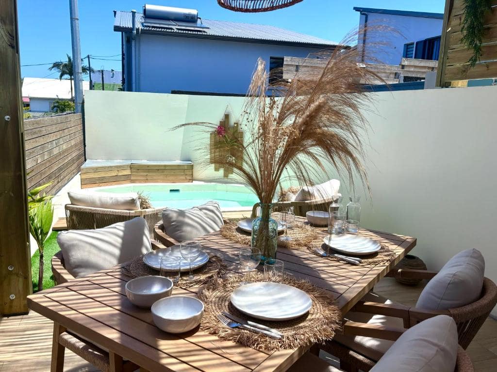 Table dressée en terrasse, piscine et pampas en fond · © Ti Cocoon