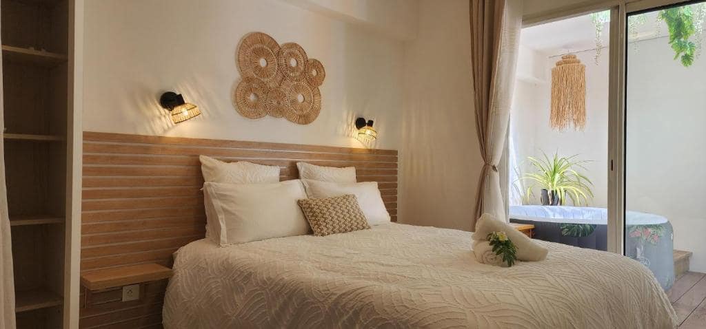 Chambre bois avec décoration murale rotin et lit double · © Ti Kaz Angelyn