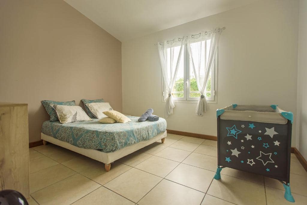 Chambre avec grand lit à côté d'un lit bébé étoilé · © Ti Kaz Bibass