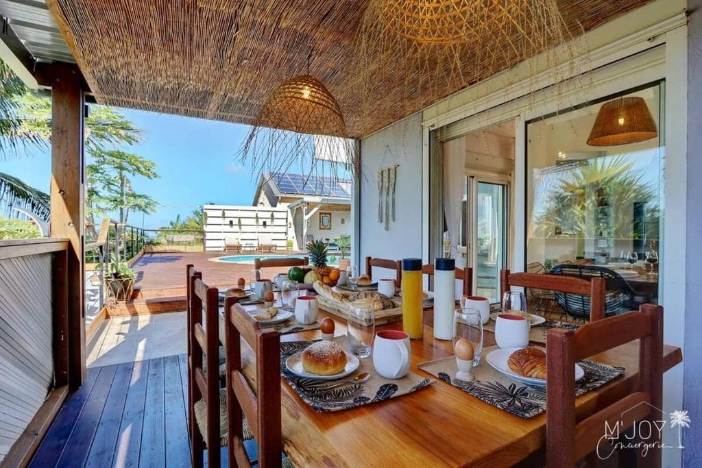 Petit-déjeuner dressé sous varangue en paille tressée · © Villa Amara