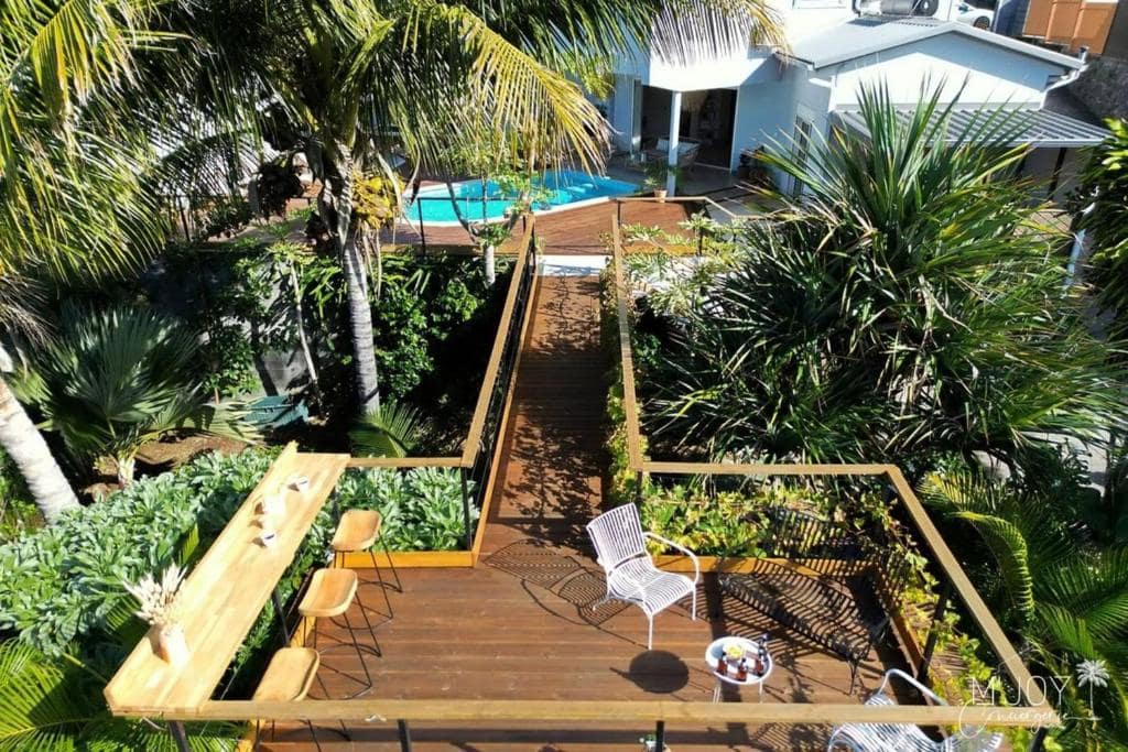 Deck en bois et piscine vus depuis le mange-debout · © Villa Amara