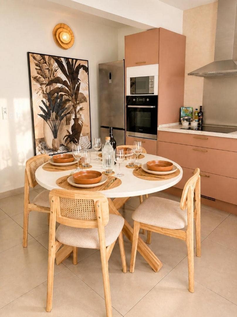 Coin repas rond et cuisine terracotta · © Villa Arum