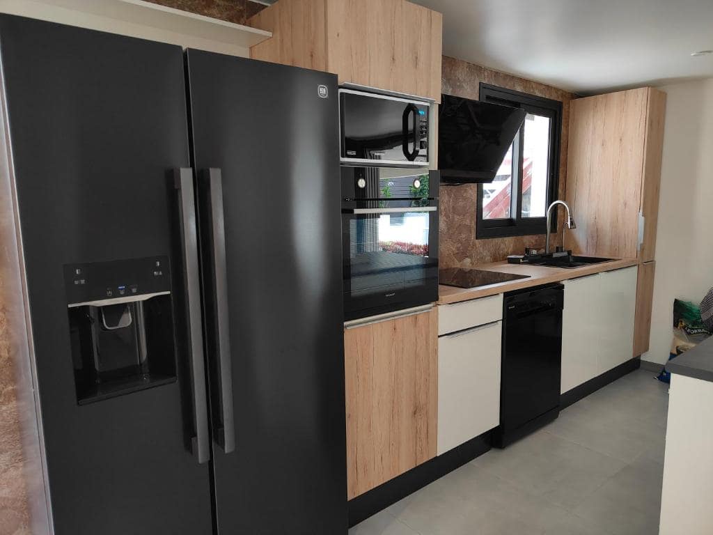 Cuisine équipée en enfilade, frigo américain et four encastré · © Villa au coeur de marius