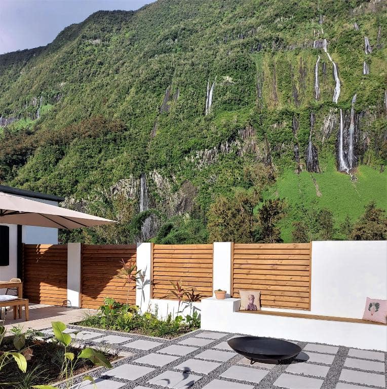 Vue en plein jour sur les cascades qui strient le rempart derrière la villa · © Villa Couleur Nature