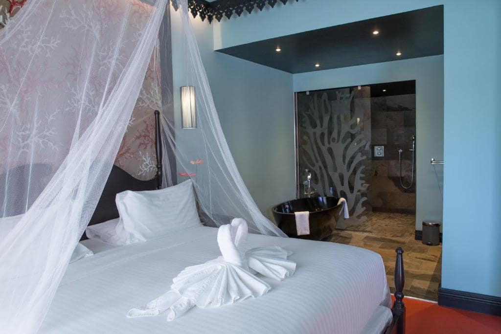 Chambre supérieure, baldaquin et baignoire ouverte sur la chambre · © Villa Delisle Hôtel & Spa