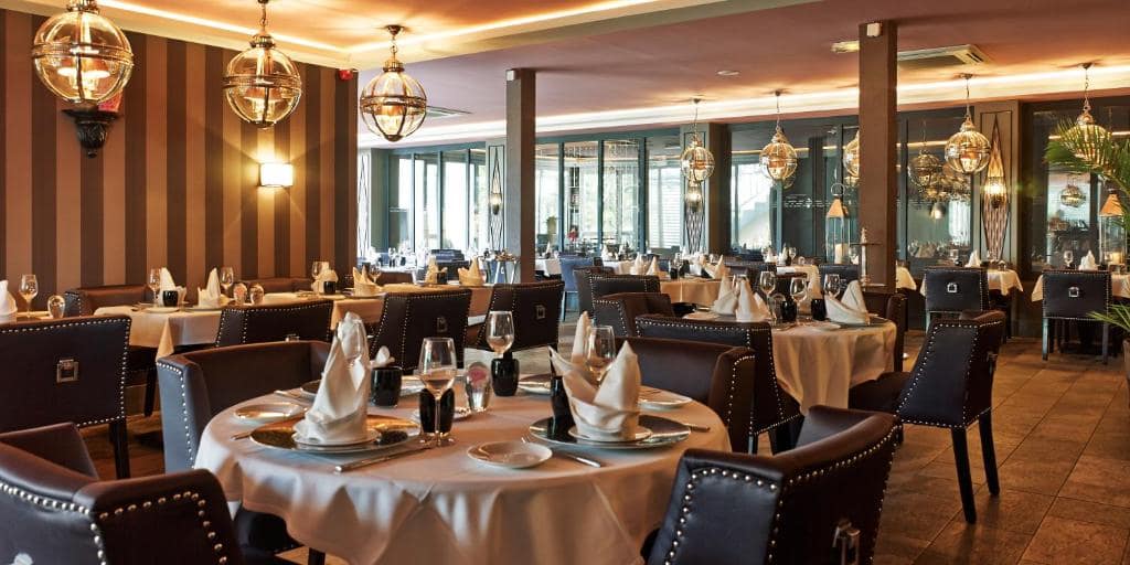 Salle du restaurant, suspensions boule et nappage blanc · © Villa Delisle Hôtel & Spa
