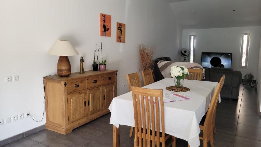 Salle à manger dressée devant le buffet en bois massif · © Les Lataniers
