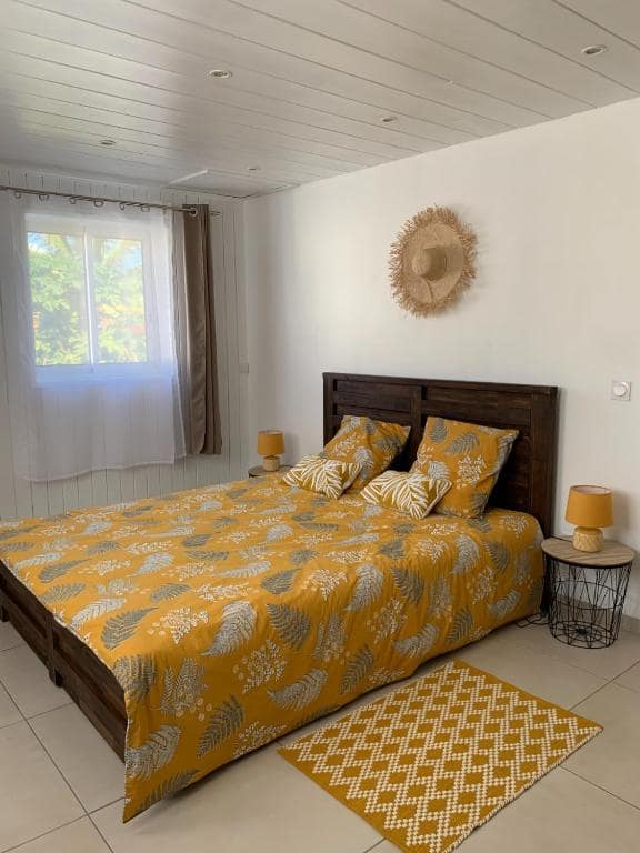 Chambre avec parure jaune et chapeau de paille en applique · © Villa Loret