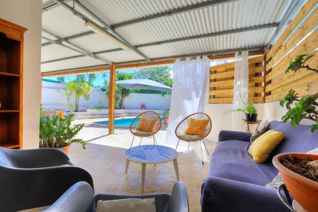 Salon extérieur ouvert sur le bassin · © La Villa M&M