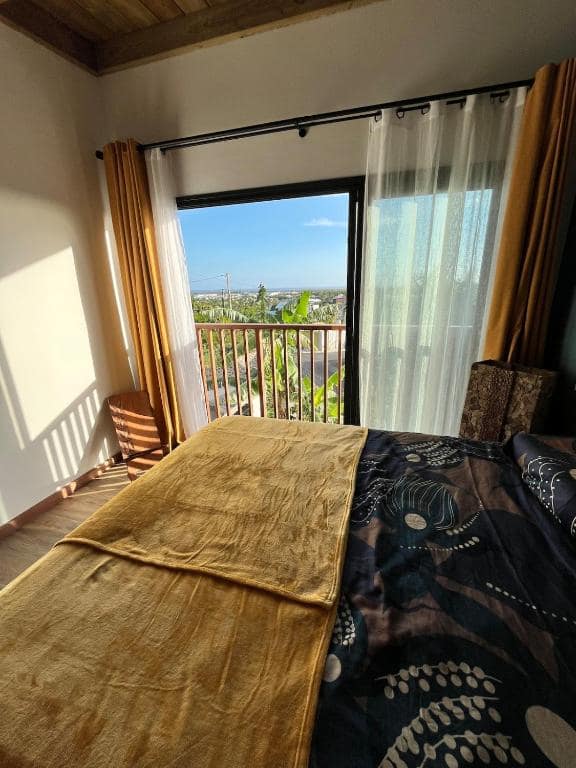 Baie vitrée de la chambre sur balcon et vue vers l'océan · © Villa neuve vue mer