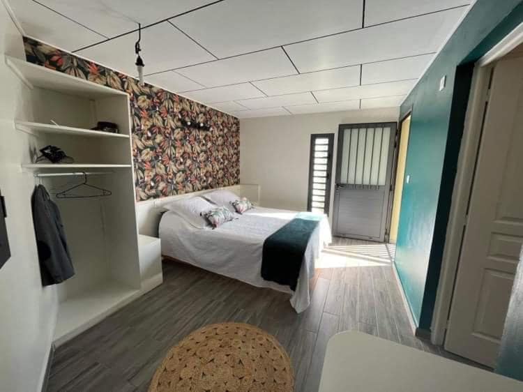 Chambre à motif végétal, portes sur le jardin et penderie blanche · © Villa Niagara avec Spa