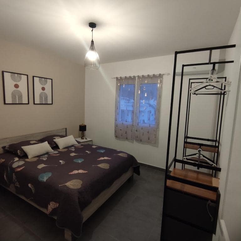Chambre avec dressing métal noir et plaid à motif feuilles · © Villa de la Rivière du Mât