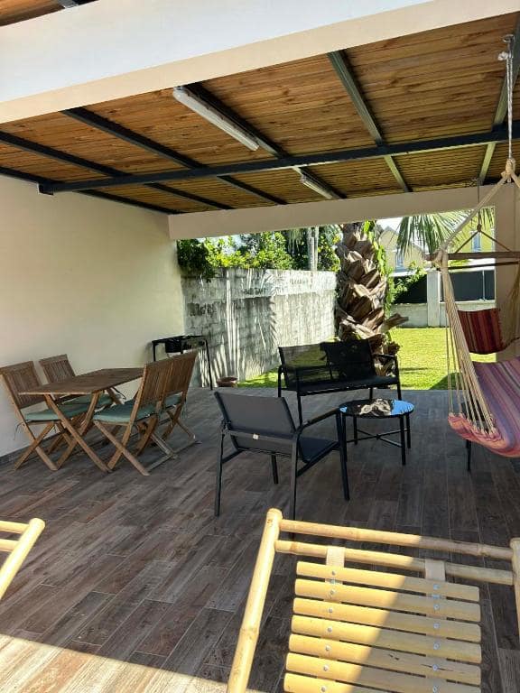 Terrasse couverte bois avec table à manger et hamac tressé · © Villa Valérie